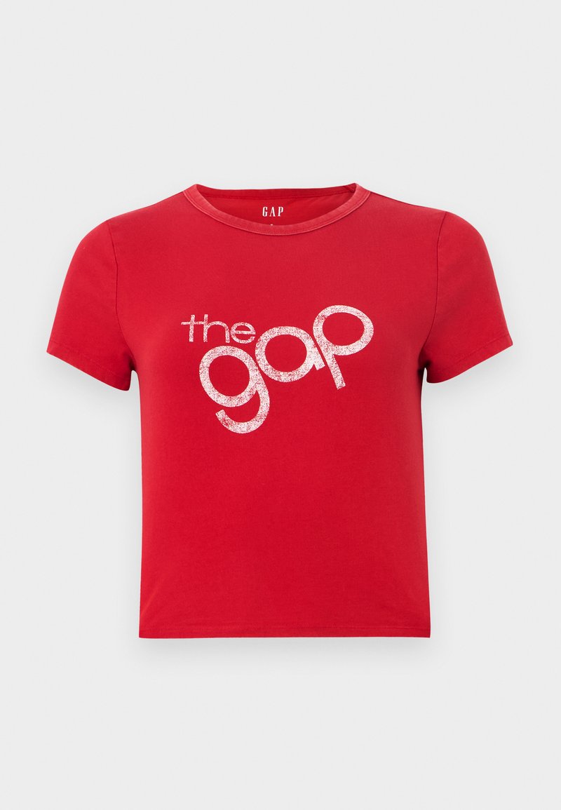 Rotes Baumwoll-T-Shirt mit kurzen Ärmeln, Rundhalsausschnitt und einem großen, weißen, glitzernden Textlogo "the gap" in der Mitte. Einfaches Design, keine Muster.