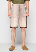 Beige Shorts mit einem verwitterten, strukturierten Finish, ausgestattet mit zwei großen Seitentaschen und einem elastischen Bund. Getragen mit braunen Slippers.