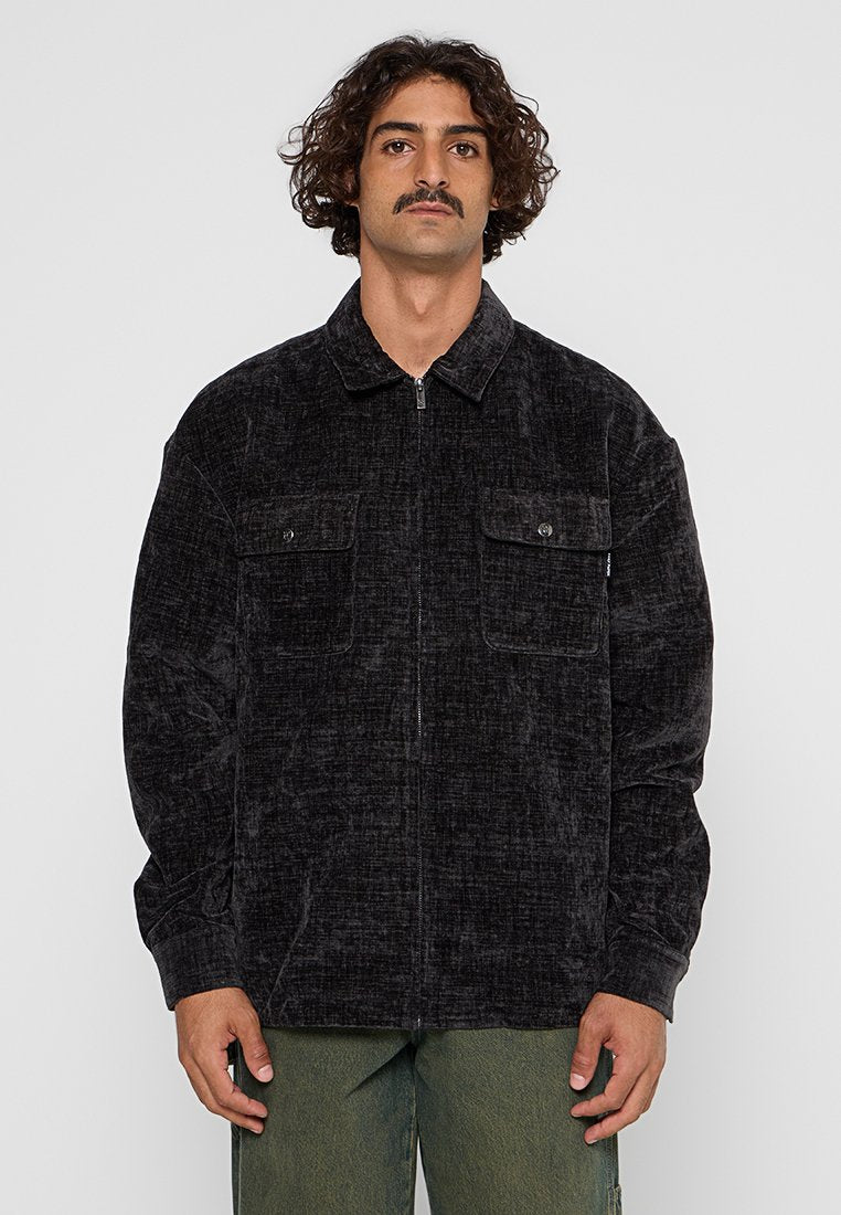 Schwarze Cordjacke mit Reißverschluss vorne, zwei Brusttaschen und einem Kragen. Aus strukturiertem Stoff und lässiger Passform.