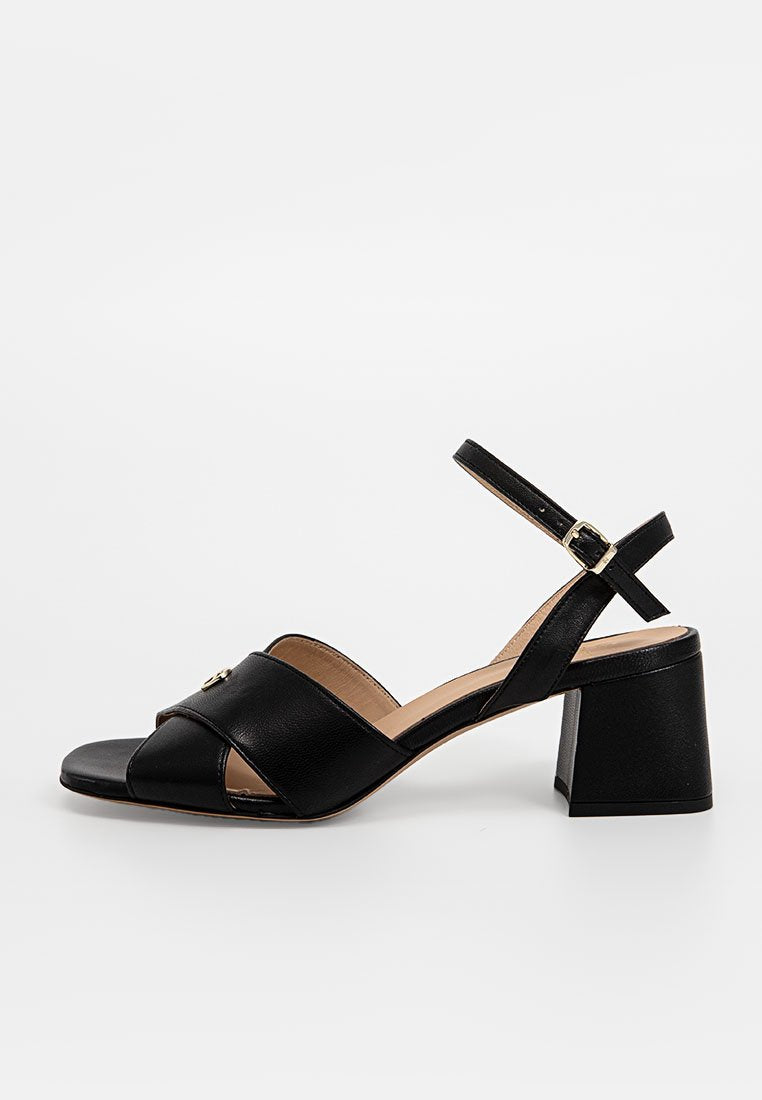 Schwarze Leder-High-Heelsandalen mit einem offenen Zehendesign, ausgestattet mit überkreuzten Riemen und einem Schnallenverschluss. Klobiger, quadratischer Absatz.