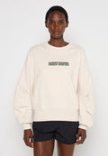 Cremefarbene, oversized Sweatshirt mit gerippten Bündchen und Saum, das ein grünes "DAILY PAPER"-Logo auf der Vorderseite trägt. Aus weichem Baumwollmaterial.