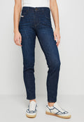 Dunkelblaue, hochgeschnittene Jeans aus Denim mit geradem Schnitt, fünf Taschen und einem Knopfverschluss. Getragen mit weißen Schuhen.