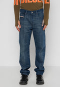 Dunkelblaue Denim-Jeans mit geradem Bein, Fünf-Taschen-Design und leichter Ausbleichung. Kombiniert mit einem olivfarbenen Langarmoberteil und schwarzen Sneakers.