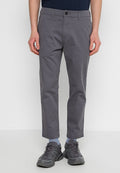 Graue, leichte Hose mit geradem Schnitt, mit Knopfverschluss und Fronttaschen. Getragen mit dunklen Sport Schuhen und blauen Socken.