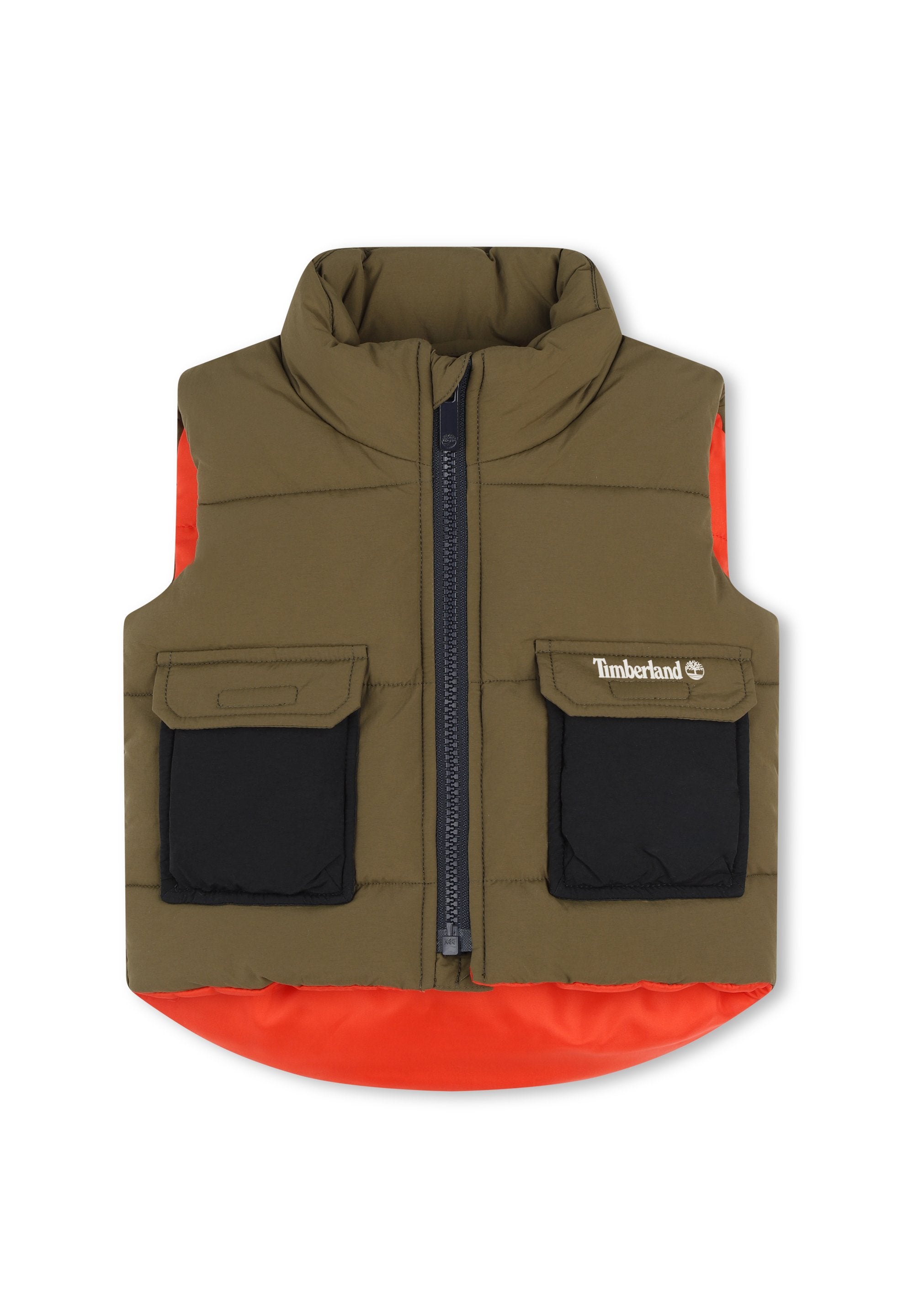 Gepolsterte Weste mit hohem Kragen, olivgrüner Hauptkörper, orangefarbener unterer Saum, schwarze Taschen und Frontreißverschluss. Timberland-Logo auf der Brust.