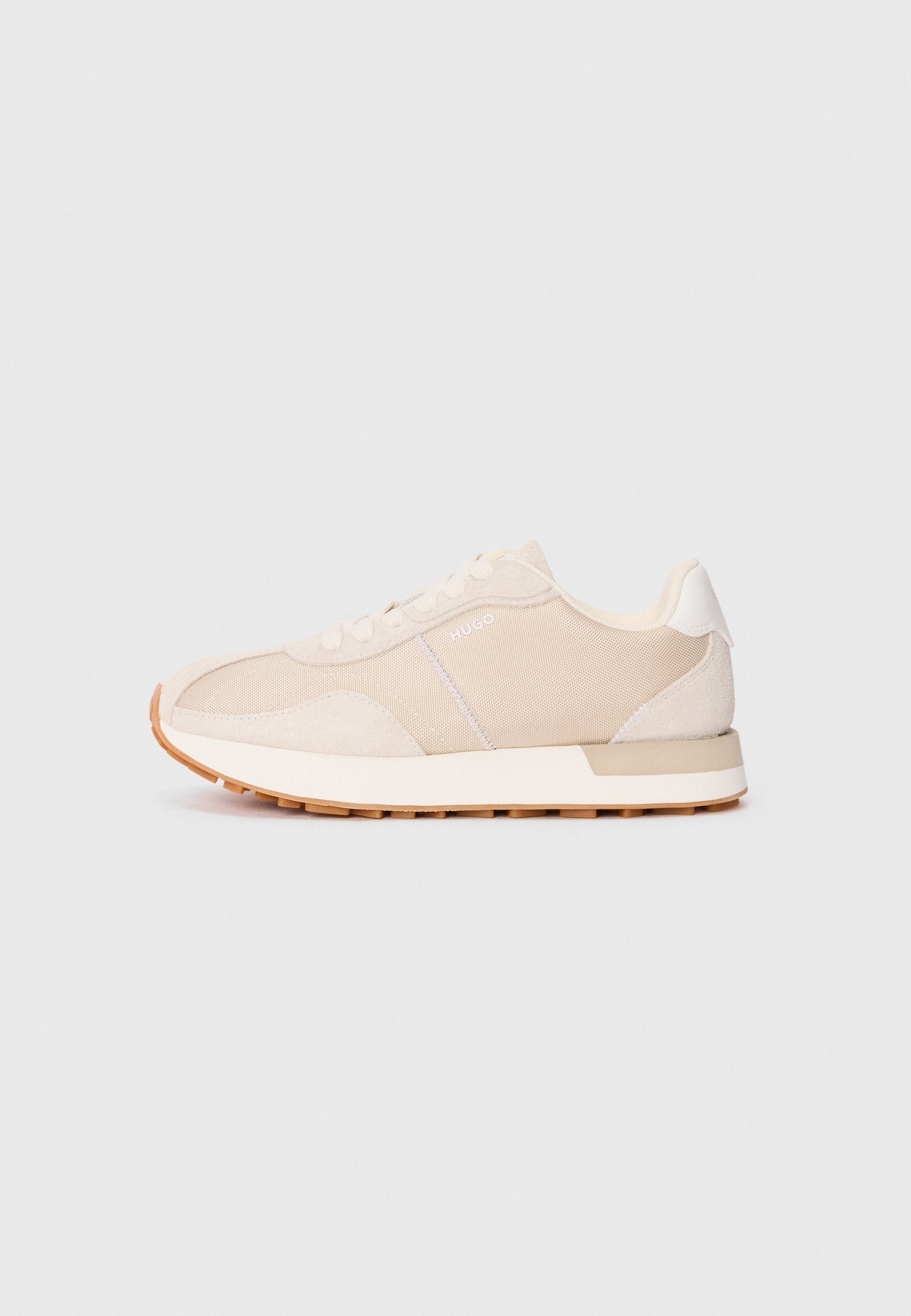 Helle beige Sneakers mit Obermaterial aus Mesh und Wildleder, weißen Akzenten, Schnürverschluss und Gummisohle. Verfügt über ein klassisches sportliches Design.