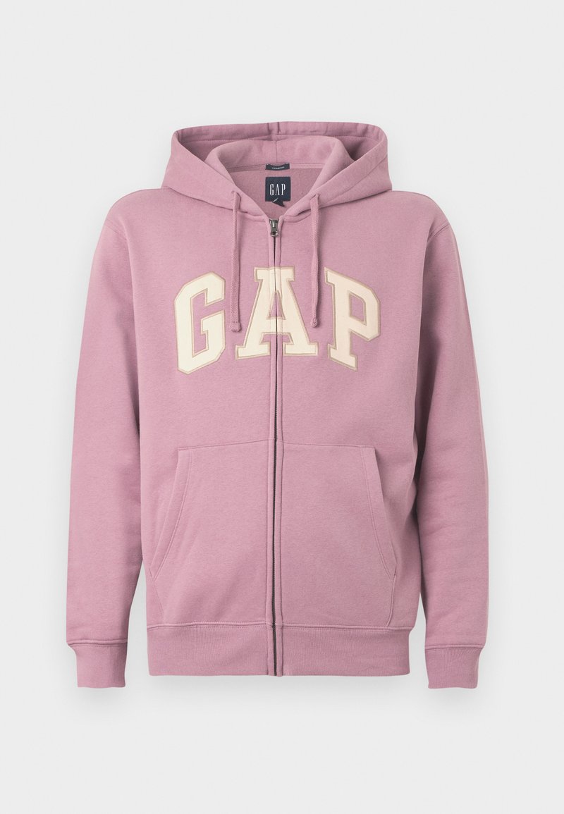 Rosa Zip-Hoodie mit Kordelzügen, auf der Vorderseite mit einem großen cremefarbenen "GAP"-Logo. Es hat zwei Fronttaschen und gerippte Bündchen.