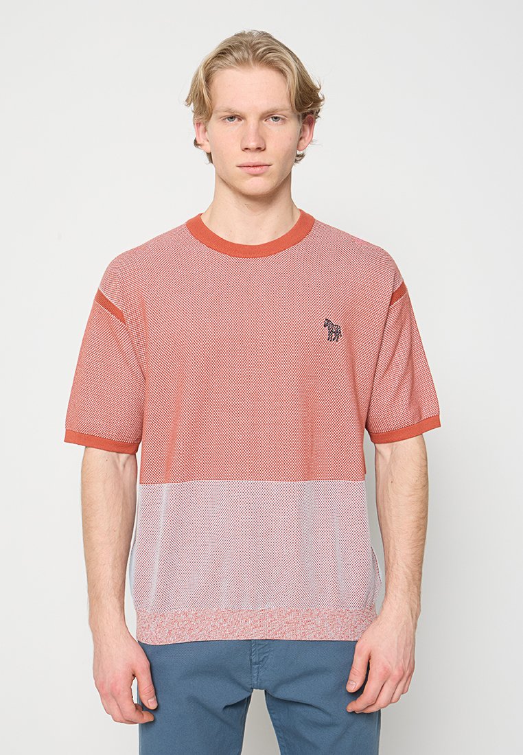 Rotes Netz-Kurzarm-T-Shirt mit kontrastierendem, festem rotem Kragen, versehen mit einem kleinen schwarzen Logo auf der linken Brust. Einfaches, leichtes Design.
