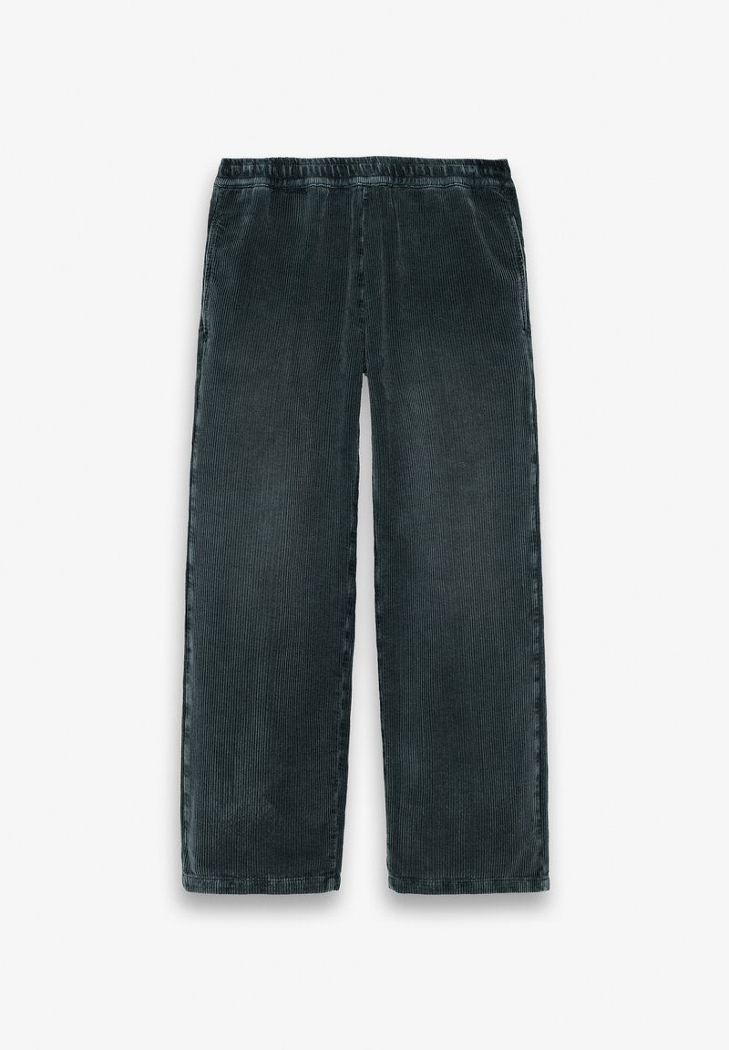 Dunkelgrüne Cord-Hose mit weitem Bein, elastischem Bund und seitlichen Taschen, flach auf weißem Hintergrund liegend.