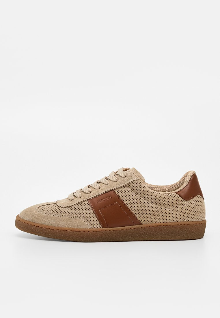 Beiger Wildleder-Sneaker mit braunen Lederakzenten, perforierten Seiten, Schnürdesign und flacher brauner Gummisohle, mit "Aigner" auf dem Seitenpanel.