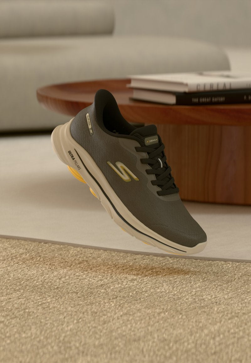 Schwarzer und grauer Sportschuh mit beiger Sohle und gelben Akzenten, schwebend über einem beigen Teppich nahe einem Holztisch mit aufgestapelten Büchern.