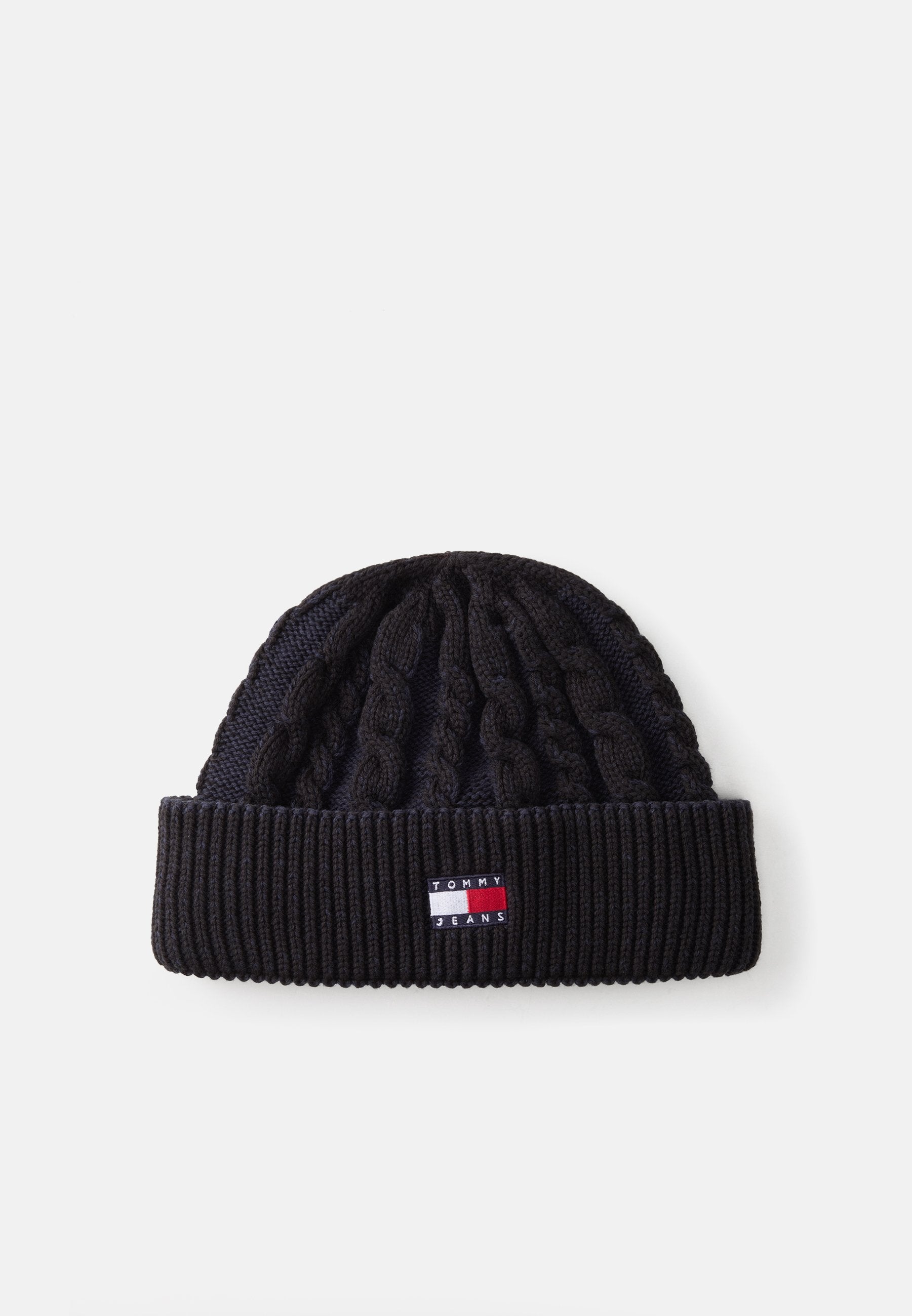 Strickmütze in Schwarz mit geripptem Saum, der ein erhabenes Kabelmuster aufweist. Enthält ein kleines Logopatch mit roten, weißen und blauen Akzenten.