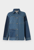 Jeansjacke mit Knopfleiste, aufgesetzten Taschen, kontrastierenden dunklen Jeansärmeln und rohem Saum an der unteren linken Tasche.