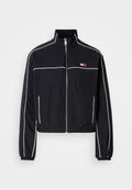 Schwarze, kürzere Jacke mit weißen Paspeln, ausgestattet mit einem hohen Kragen, Reißverschluss vorne und kleinem Logo auf der Brust. Hergestellt aus leichtem Stoff.