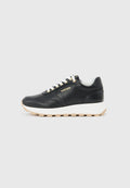 Schwarzer Ledersneaker mit weißen Schnürsenkeln, dicker weißer Sohle, beigem Profil und goldenem "AIGNER"-Logo an der Seite, seitlich dargestellt.