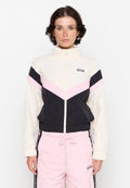Windbreaker-Jacke mit einem Farbschnitt in Weiß, Schwarz und Pink, einem Reißverschluss vorne und elastischen Bündchen. Kombiniert mit rosa Sweatpants.