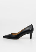 Schwarzer Damen-Pumps aus Leder mit spitz zulaufender Spitze, niedrigem Kitten-Heel und kleinem goldenen Akzent nahe der Spitze vor weißem Hintergrund.