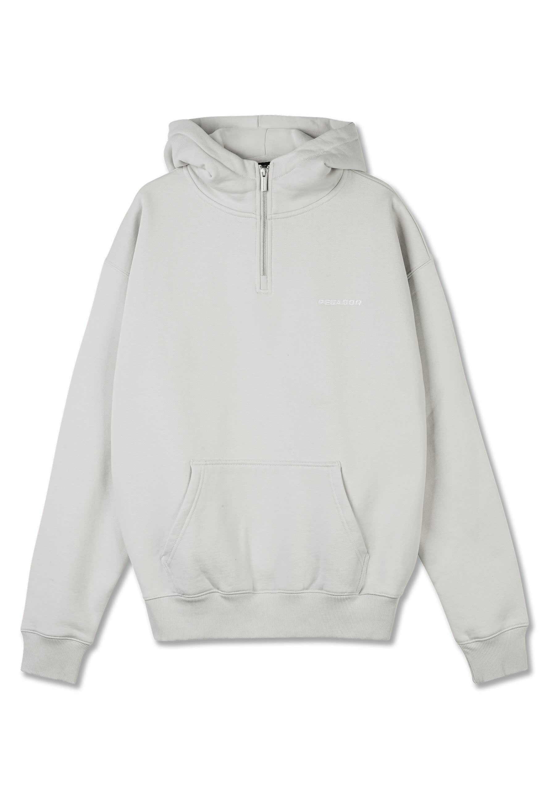 Helles grauer Hoodie aus weichem Material, mit einem halben Reißverschluss vorne, einer Kängurutasche, gerippten Bündchen und einem kleinen weißen Logo auf der Brust.