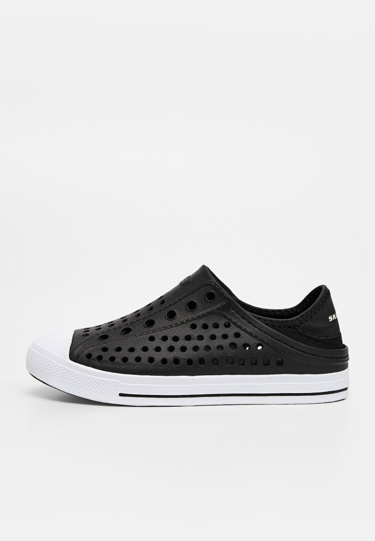 Schwarzer Slip-On-Sneaker mit mehreren runden Perforationen, weißer Gummisohle und weißer Zehenkappe, von der linken Seite betrachtet.