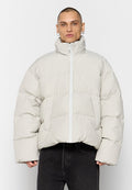 Beige gepolsterte Jacke mit hohem Kragen, Reißverschluss und weiten Ärmeln. Verfügt über ein diagonales Steppmuster und Fronttaschen.