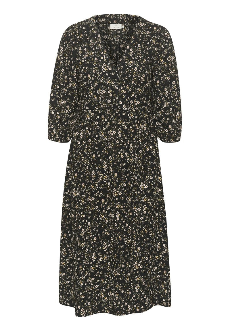 Schwarzes Blumenkleid mit V-Ausschnitt, Dreiviertelärmeln und taillierter Taille. Das Muster zeigt kleine weiße und gelbe Blumen überall.