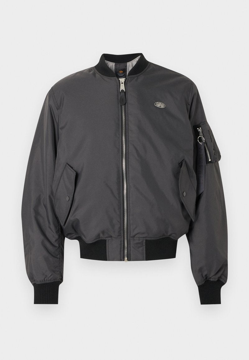 Schwarze Bomberjacke mit Frontreißverschluss, gerippten Bündchen und Saum, Pattentaschen und einer Reißverschlusstasche mit Schlüsselring am linken Ärmel.