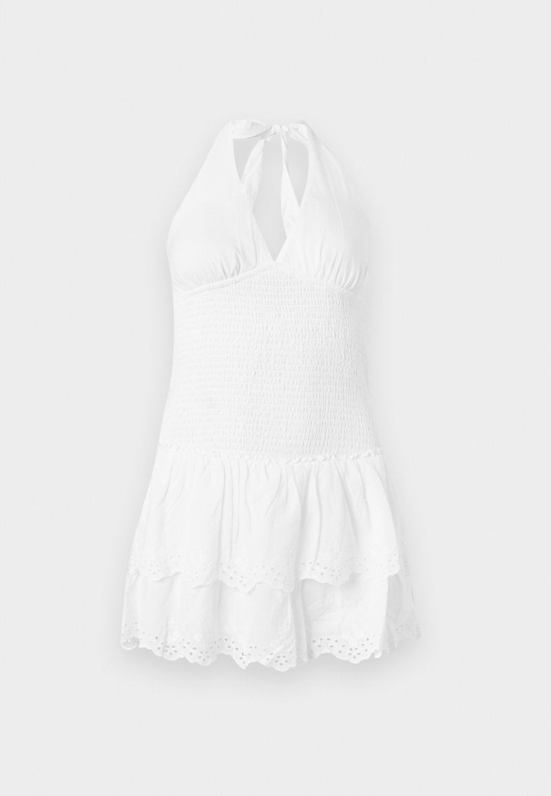 Weißes Halterneck-Kleid mit einem geschoppten Oberteil und gestuften Rock. Mit einem gewellten Saum und Lochstickerei am unteren Rand. Sanfte Baumwolltextur.