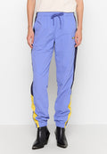 Helle blaue Hose mit marineblauen und gelben Seiteneinsätzen, hergestellt aus einem glatten Material, mit einem elastischen Bund und schmal zulaufenden Bündchen.