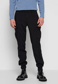 Schwarze Cargo-Hosen mit Seitentaschen, elastischen Bündchen und lockerem Schnitt. Kombiniert mit einem hellblauen Pullover und schwarzen Stiefeletten.