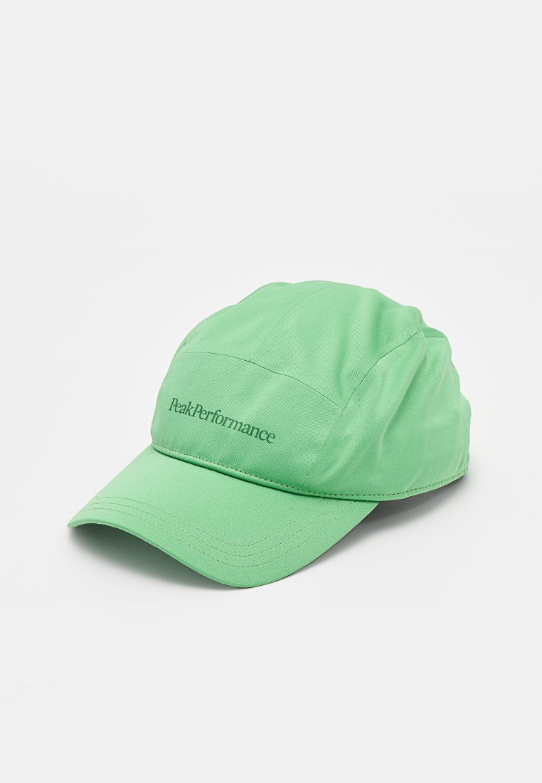 Hellgrüne Baseballkappe mit gebogenem Schirm und vorne mit dem "Peak Performance"-Logo bestickt vor weißem Hintergrund.