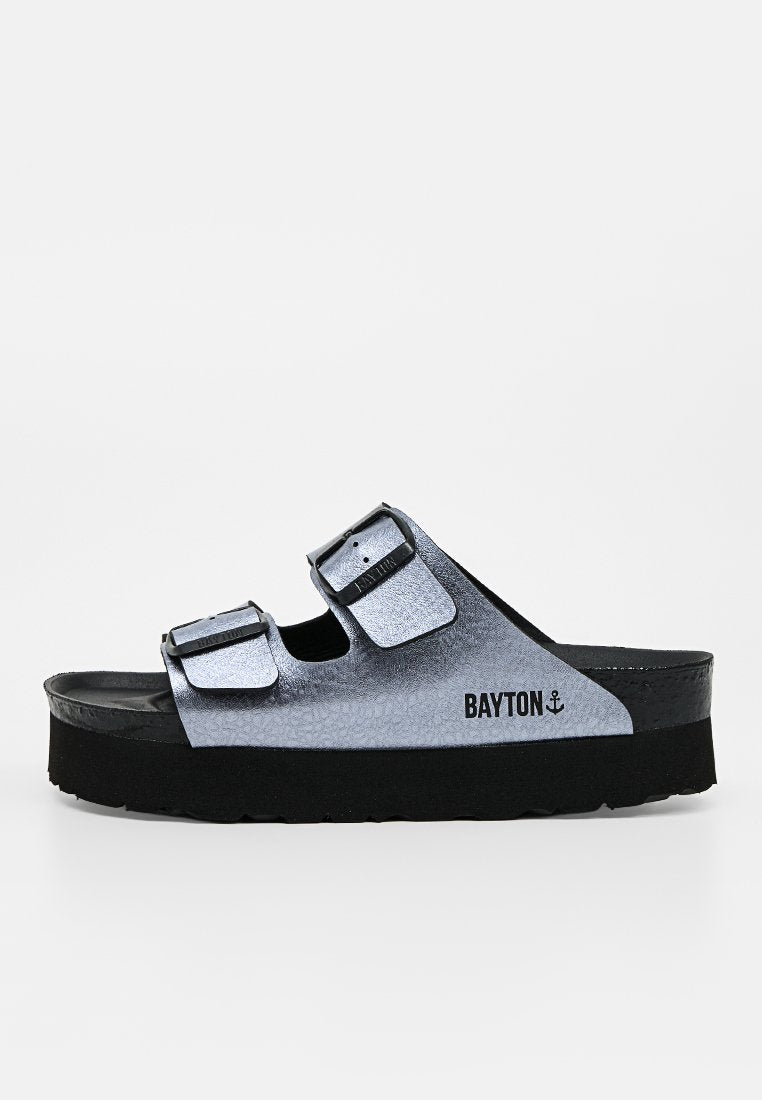 Silberne Slidesandale mit zwei verstellbaren Schnallenriemen und einer dicken schwarzen Sohle, gebrandmarkt mit "BAYTON" und einem Ankersymbol an der Seite.