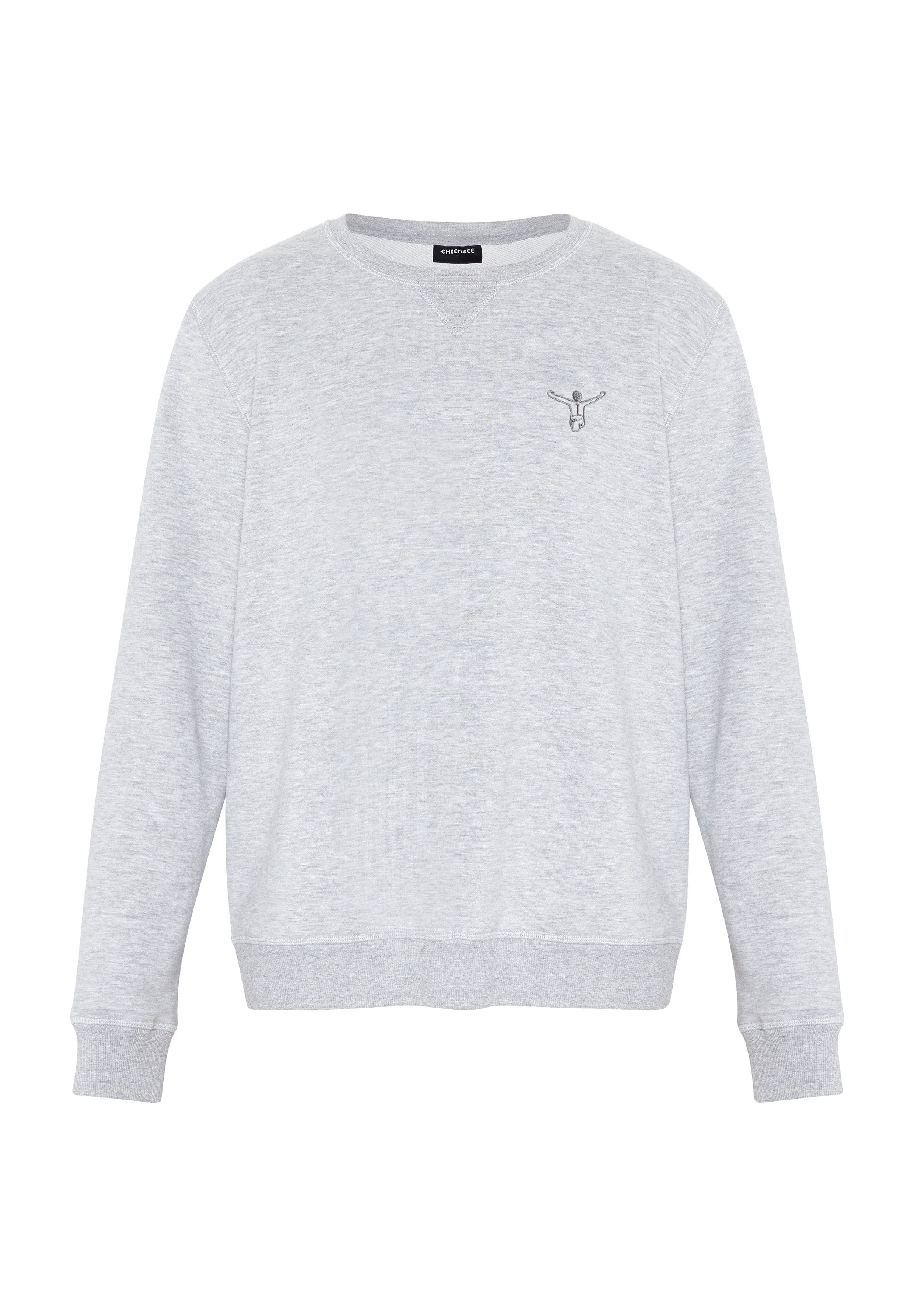 Hellgraues Sweatshirt mit Rundhalsausschnitt und langen Ärmeln, mit einer kleinen dunkelgrauen, gestickten Figur mit erhobenen Armen auf der linken Brust.