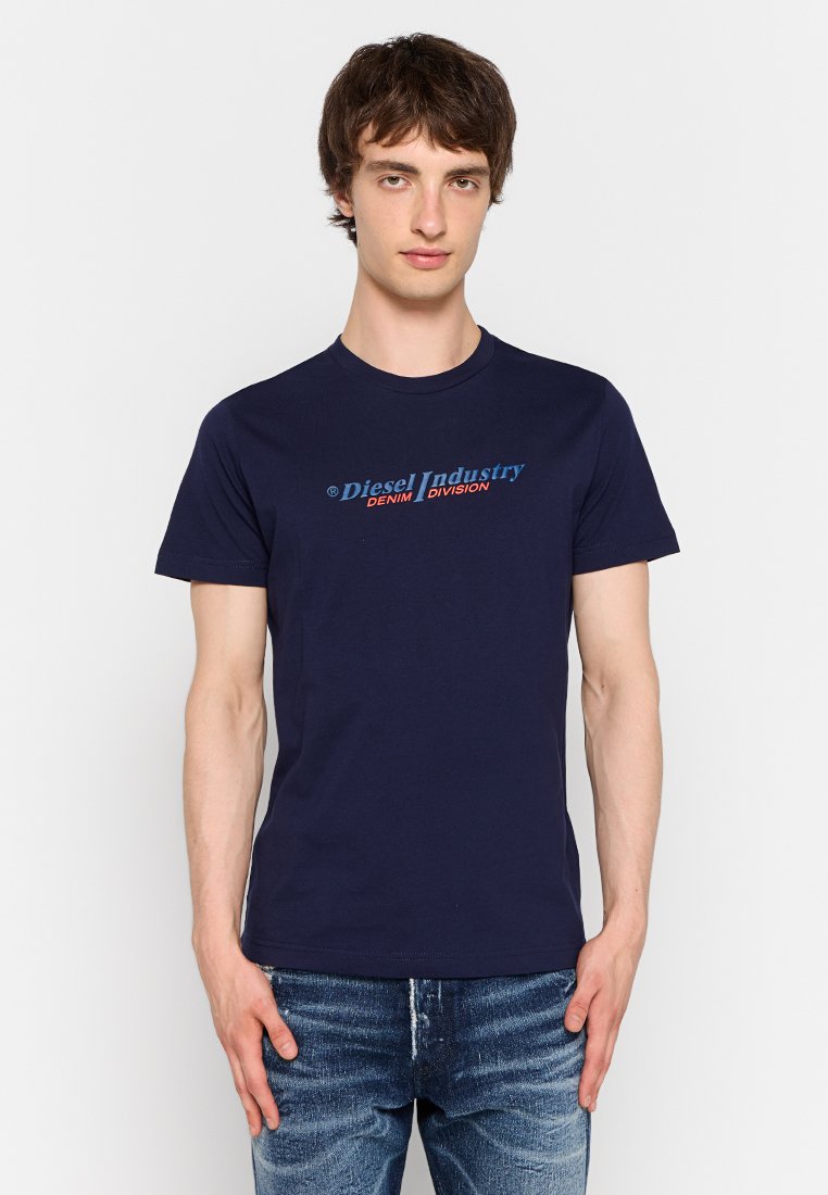 Navyblaue Baumwoll-T-Shirt mit einem Logo in blauen und roten Buchstaben, das "Diesel Industry DENIM DIVISION" auf der Brust sagt. Lässiger Schnitt.