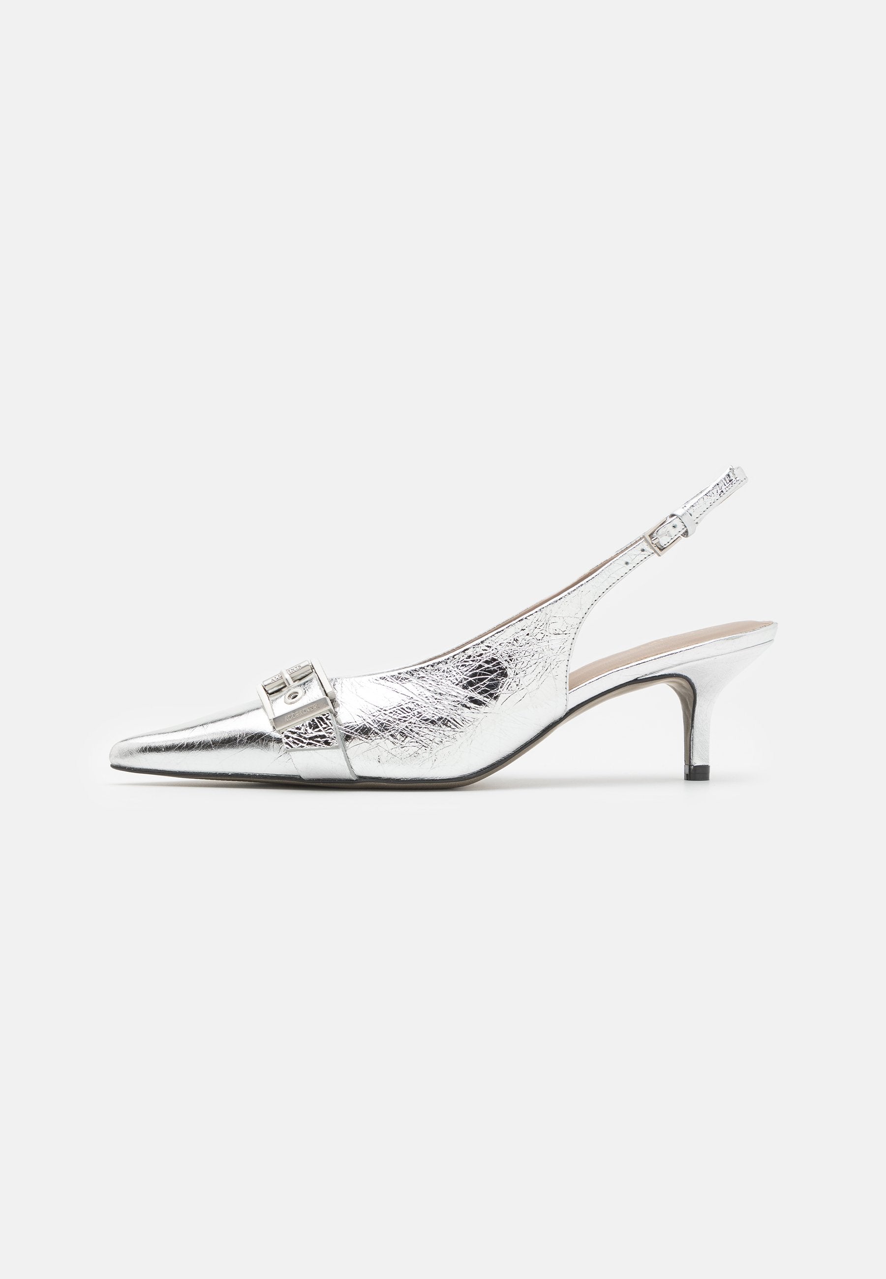 Silberne Slingback-Absätze mit einer spitzen Zehe, ausgestattet mit einer strukturierten Oberfläche und einer Schnallenverzierung am Riemen. Niedriger, schlanker Absatz.