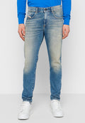 Hellblaue Jeans aus Denim mit einem ausgewaschenen Finish, ausgestattet mit fünf Taschen, einem Knopfverschluss und geradem Bein, getragen mit weißen Sneakers.