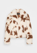 Kunstpelzjacke mit einem Kuhmuster in Weiß und Braun. Sie verfügt über einen Kragen, hat ein verkürztes Design und lange Ärmel. Das Innere ist in Beige.