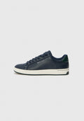 Marineblaue Ledersneaker mit weißer Gummisohle, abgerundetem Zehenbereich und flachen Schnürsenkeln. Enthält einen grünen Akzent an der Ferse und ein dezentes Markenlogo an der Seite.