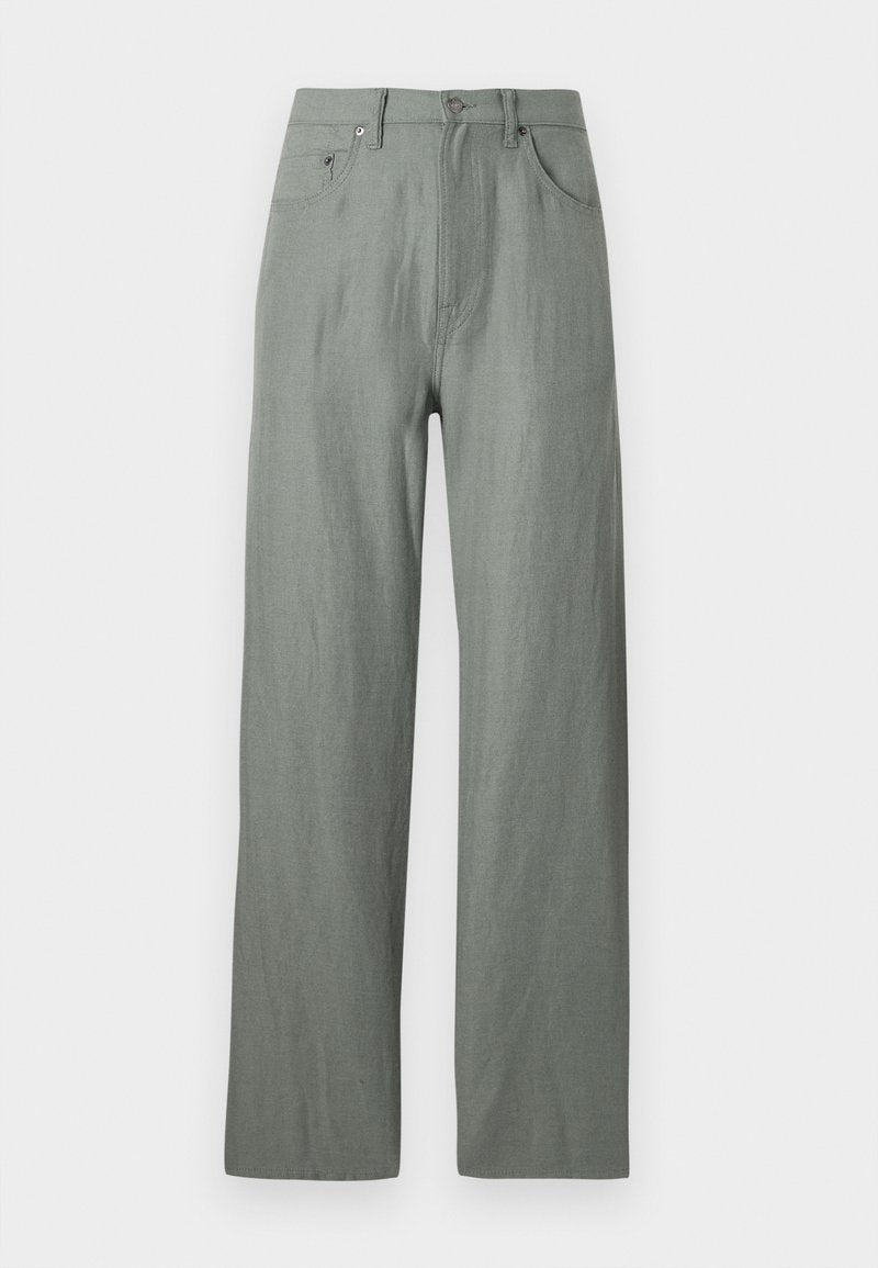 Helle grüne, weite Hosen aus einem weichen, strukturierten Stoff. Merkmale sind ein vorderer Knopfverschluss und fünf Taschen.