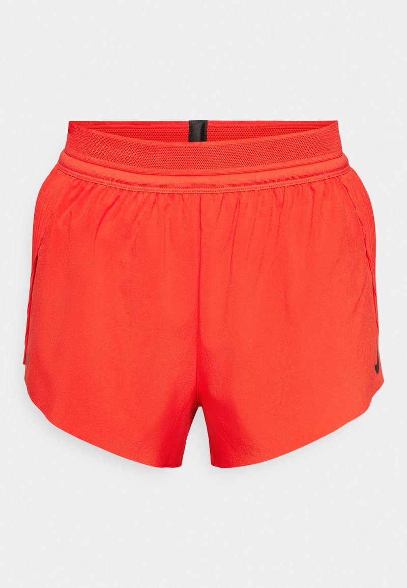 Rote Sportshorts aus leichtem Stoff mit einem elastischen Bund, seitlichen Taschen und einem kleinen schwarzen Logo am Saum.