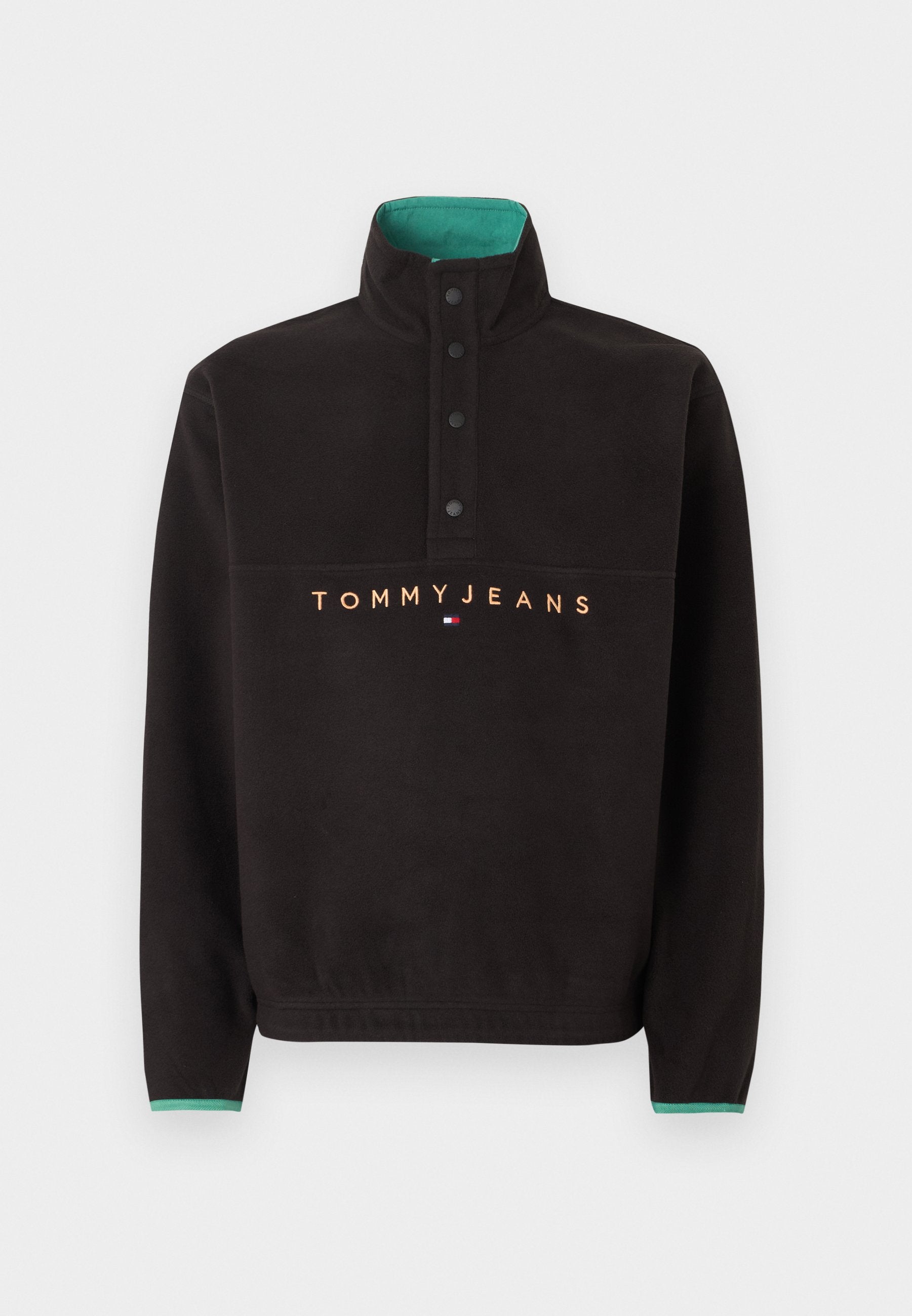 Schwarzer Fleecepullover mit hohem Kragen, vier schwarzen Druckknöpfen, grünem Innenkragen und "TOMMY JEANS" Schriftzug mit Logo auf der Brust.