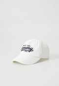 Weiße Baumwollmütze mit gebogenem Schirm und blauer gestickter Schrift "Tommy Jeans est. 1985." Einfaches Design ohne zusätzliche Verzierungen.