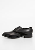 Schwarze Leder-Schnürschuhe mit einem glatten Finish und einem matten schwarzen Wildleder-Panel an der Seite. Niedriger Absatz mit einem abgerundeten Zehendesign.