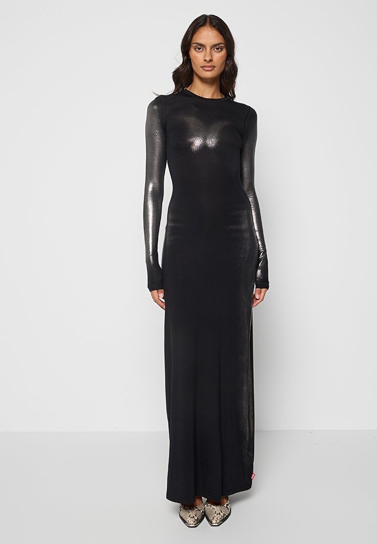 Langes schwarzes Kleid mit langen, enganliegenden Ärmeln. Durchsichtige Textur an den Ärmeln, schlanker Schnitt und ein leichtes Glänzen. Akzentuiert mit Schuhen im Schlangenmuster.
