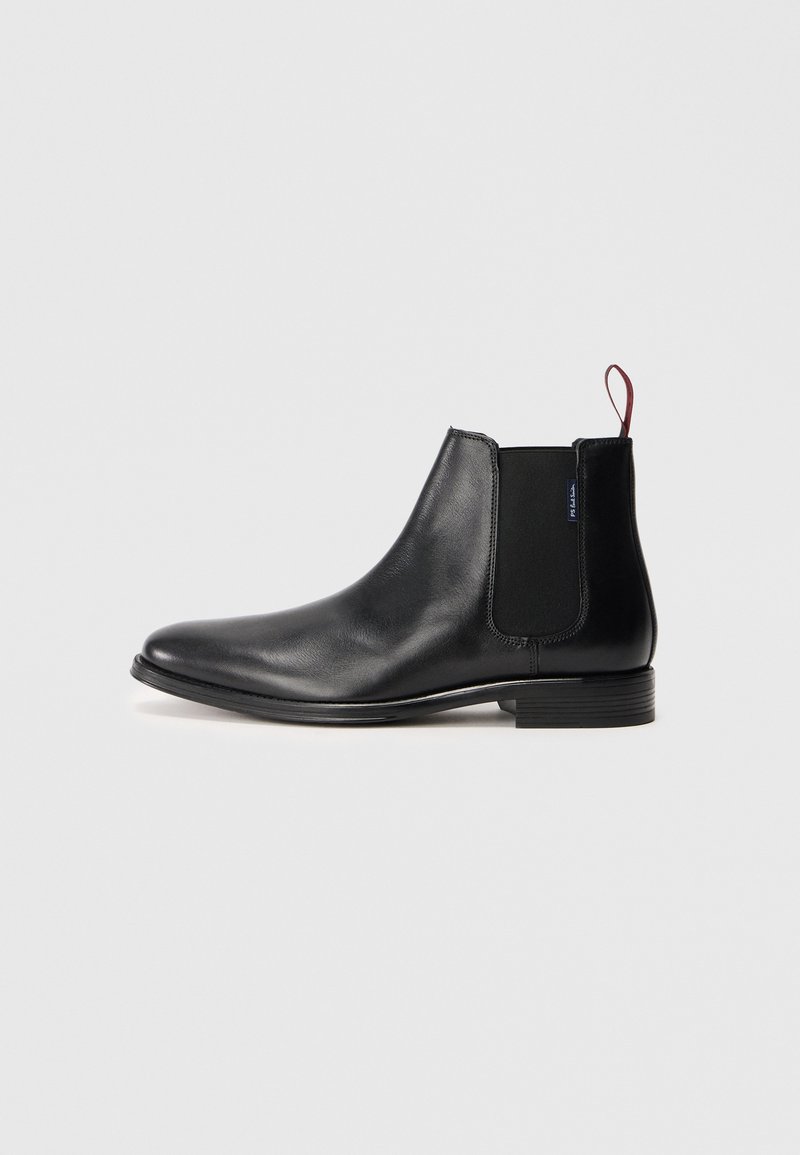 Schwarze Leder-Chelsea-Stiefel mit elastischem Seitenpaneel und einer roten Schlaufe an der Rückseite, auf einem schlichten weißen Hintergrund präsentiert.