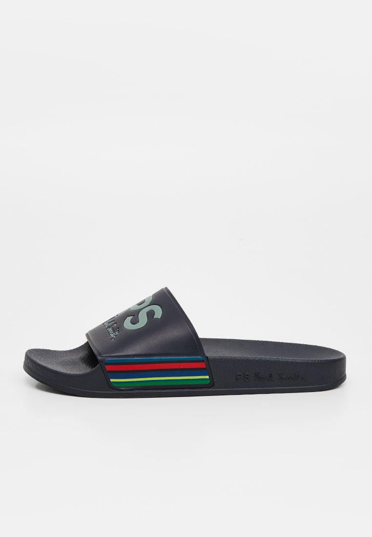 Marineblaue Slide-Sandale mit einem breiten Riemen, der hellgrüne Schrift und bunte horizontale Streifen in Rot, Grün und Blau zeigt. Genoppte Sohle.