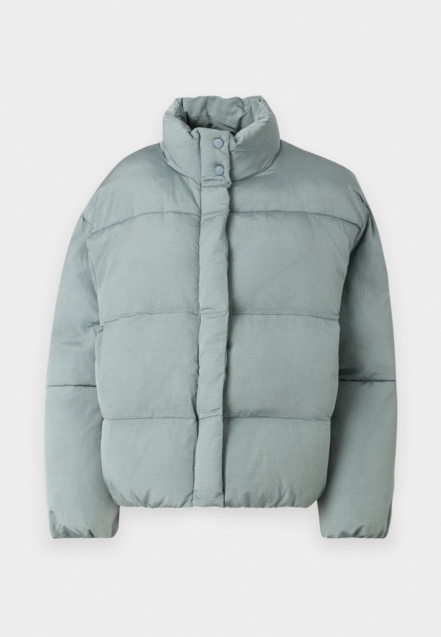 Hellgrüne Steppjacke mit Stehkragen, Druckknöpfen und horizontaler Stepptextur. Weicher Stoff, leicht oversized geschnitten.