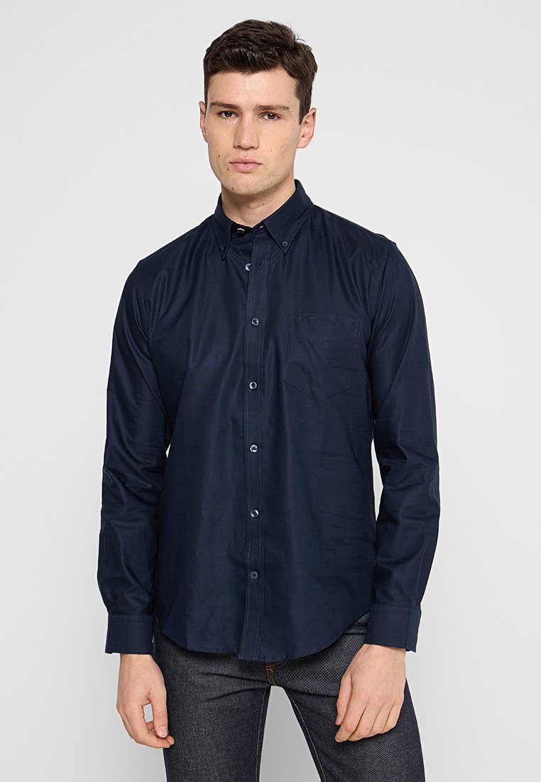 Navy Button-Up-Hemd aus Baumwollmischgewebe mit Kragen, langen Ärmeln, einer Brusttasche und einem dezenten Glanz.