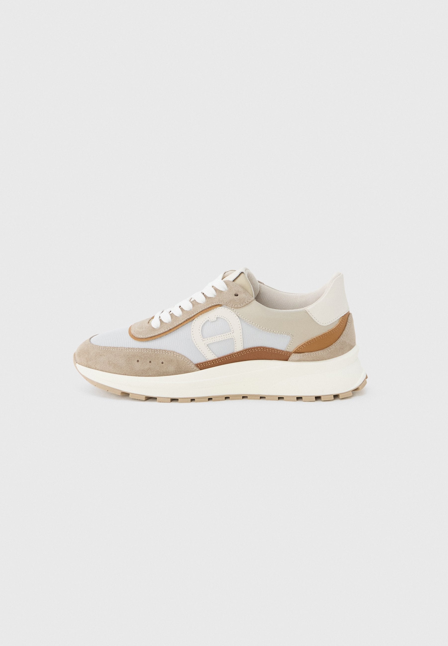 Sneaker mit niedrigem Profil in Beige, Weiß und Braun mit Wildleder- und Mesh-Paneelen, weißen Schnürsenkeln und dicker cremefarbener Sohle vor einfarbigem Hintergrund.