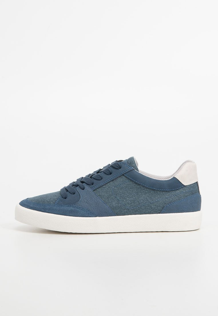 Blaue Leinensneaker mit strukturiertem Obermaterial, kontrastierenden hellgrauen Akzenten, runder Zehenpartie, Schnürverschluss und weißer Gummisohle.
