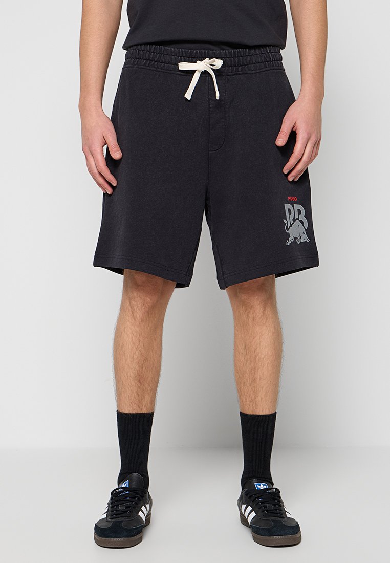 Schwarze Shorts aus weichem Stoff mit elastischem Bund und Kordelzug. Bedrucktes Logo in Grau und Rot auf dem linken Bein.